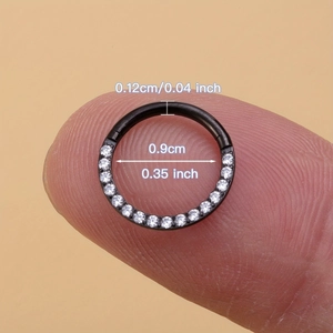 316L stainless steel black nose ring with white zircon stones on a fingertip
