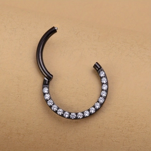 Macro detail of black hinged segment ring with paved white zircons for nose or ear