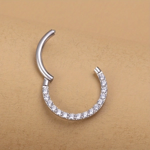 Macro detail of silver stainless steel hinged nose ring with paved white zircons