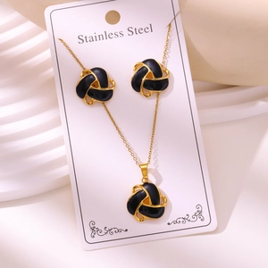 Gold-plated stainless steel jewelry set featuring black enamel knot earrings and necklace