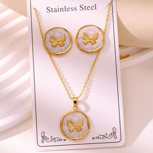 Macro view of stainless steel butterfly jewelry set with white marble texture and gold plating