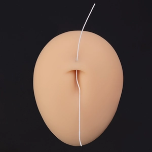Macro detail of soft silicone piercing model with a white cord on a dark background