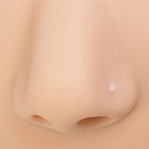Macro shot of 2mm clear acrylic nose stud on realistic skin model for piercing display