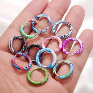 Colorful marble pattern stainless steel hoop earrings set shown in hand for size