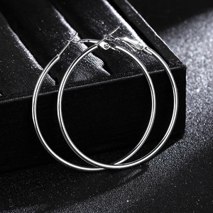 Detailed view of silver hoop earrings on a black velvet jewelry box surface
