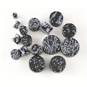 Macro shot of snowflake obsidian stone ear plugs in various sizes for gauges