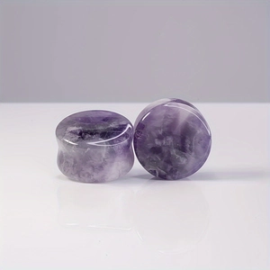 Macro shot of double flare amethyst ear plugs with natural purple stone texture