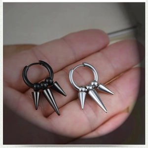 Detail view of punk style stainless steel spike earrings in black and silver finishes