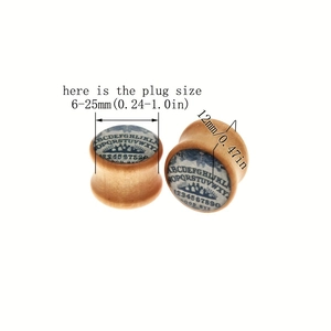 Detail view of wooden ear plugs featuring classic Ouija board design with letters and numbers