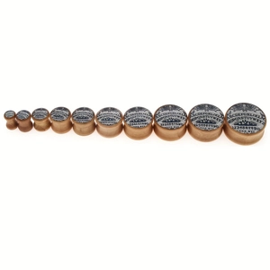 Macro view of wood ear plugs set featuring Ouija board engraving and natural grain texture