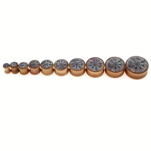 Macro view of wooden ear plugs set featuring Viking Vegvisir symbol in various sizes