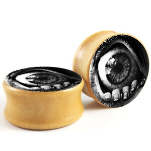 Macro detail of wood ear plugs featuring a realistic eye design in gothic art style