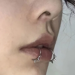 Close-up of gothic punk stainless steel lip rings with sharp studs on a model