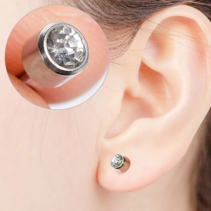 Close-up of a silver bezel-set cubic zirconia stud earring worn on a model's earlobe