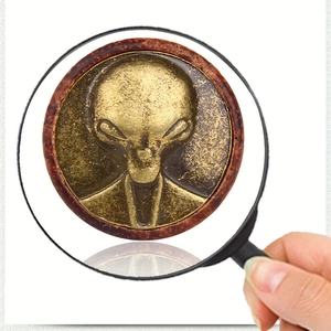 Macro shot of alien relief on antique brass with dark wood frame ear gauge jewelry
