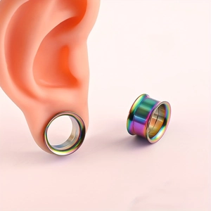 Vista macro de dilatadores de oreja de acero arcoíris con chapado al vacío y diseño metálico