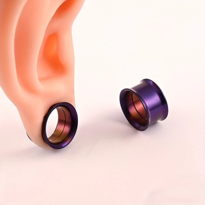 Detalle macro de túneles de oreja en acero violeta en un modelo de oreja realista