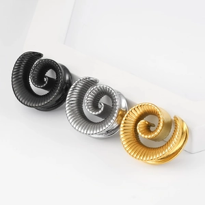 Makroaufnahme von Edelstahl-Ohrdehnerspiralen in Schwarz, Silber und Gold mit horizontaler Struktur