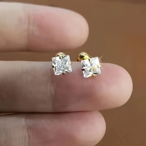 Nahaufnahme goldener quadratischer Ohrstecker mit Zirkonia im Größenvergleich gehalten