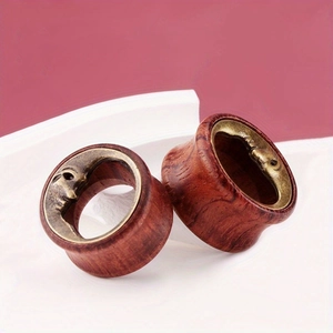 Close-up of vintage crescent moon face carving on natural wood ear gauge tunnels