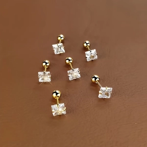 Detailansicht von drei Paaren goldener Edelstahl-Ohrstecker mit quadratischem Zirkonia-Stein