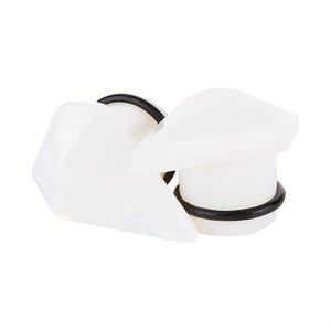 Detail of white acrylic ear plugs with geometric diamond cut surface and black O-rings