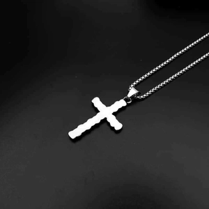 Collier croix crâne gothique en acier titane avec texture lave sur fond noir uni
