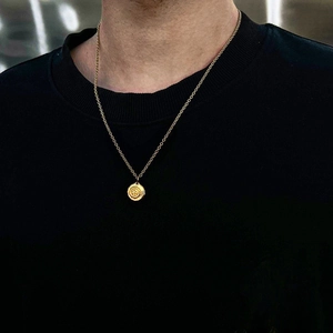 Goldene Titanstahl-Halskette mit Sonnenanhänger, getragen auf einem schwarzen T-Shirt