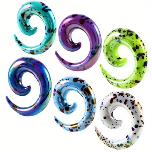 Detail of colorful spiral acrylic ear tapers with artistic paint splatter patterns