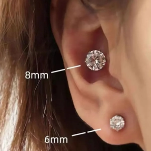 Vue macro comparant des boucles d'oreilles magnétiques de 8mm et 6mm sur l'oreille