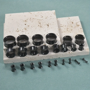 Detailset aus schwarzen Chirurgenstahl-Ohrplugs und hohlen Tunneln in verschiedenen Größen