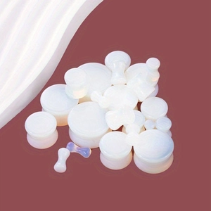 Stack of white opal stone ear plugs in multiple sizes with smooth polished finish