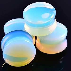 Macro shot of iridescent opalite ear plugs for piercing with blue and yellow gradients