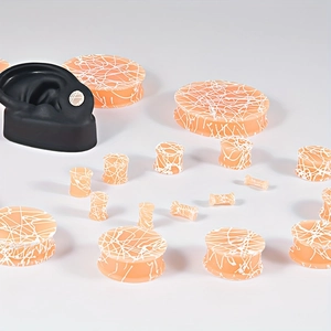 Siliconen ear tunnels met wit spinnenwebpatroon en een anatomisch oormodel