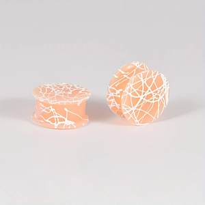 Macro-opname van huidskleurige siliconen ear plugs met wit marmeren patroon