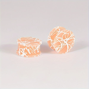 Close-up van double flared siliconen ear plugs met oranje en wit spatpatroon ontwerp