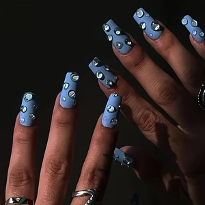 Detail of matte blue press-on nails featuring realistic 3D clear water droplets effect