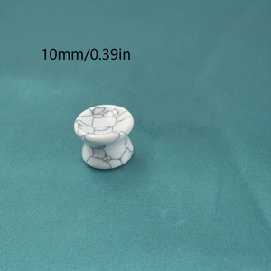 Gros plan d'un plug d'oreille de 10mm en turquoise blanche avec texture de marbre