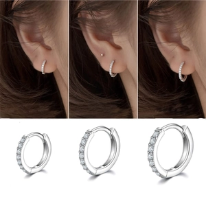 Three sizes of silver steel hoop earrings with cubic zirconia stones shown on model