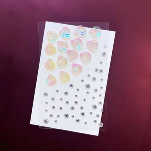 Détails de paillettes coquillage irisées et de strass transparents sur film plastique