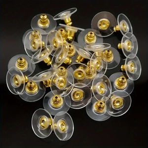 Detailed close-up of golden bullet earring backs with clear round silicone pads
