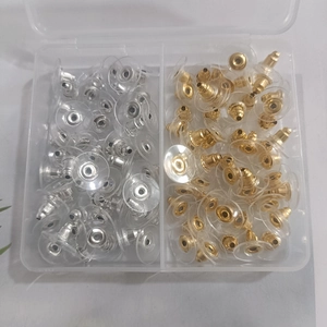Golden and silver stainless steel earring backs with clear comfort pads in a storage box