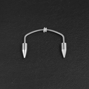 Vista macro del piercing labret curvo in acciaio inossidabile con punte a cono