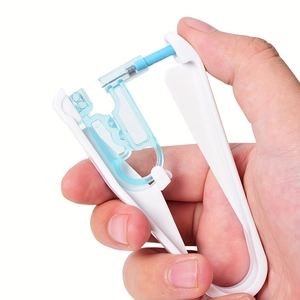 Kit de perçage d'oreille manuel jetable avec base blanche et guide bleu en main