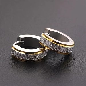 Primer plano de pendientes huggie de acero inoxidable bicolor con acabado arenado plata