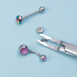 Close-up of stainless steel body piercing tools and iridescent barbell jewelry set