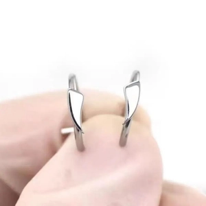 Dettaglio di piercing per labbra in acciaio inossidabile argento con ciondoli a triangolo