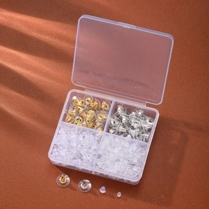 Détail du coffret à 4 compartiments rempli de fermoirs de boucles d'oreilles variés
