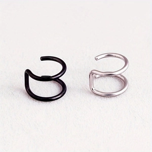Close-up of double spiral stainless steel ear cuffs in matte black and silver finishes