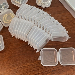 Stack of mini transparent plastic rectangular jewelry boxes for rings and necklaces